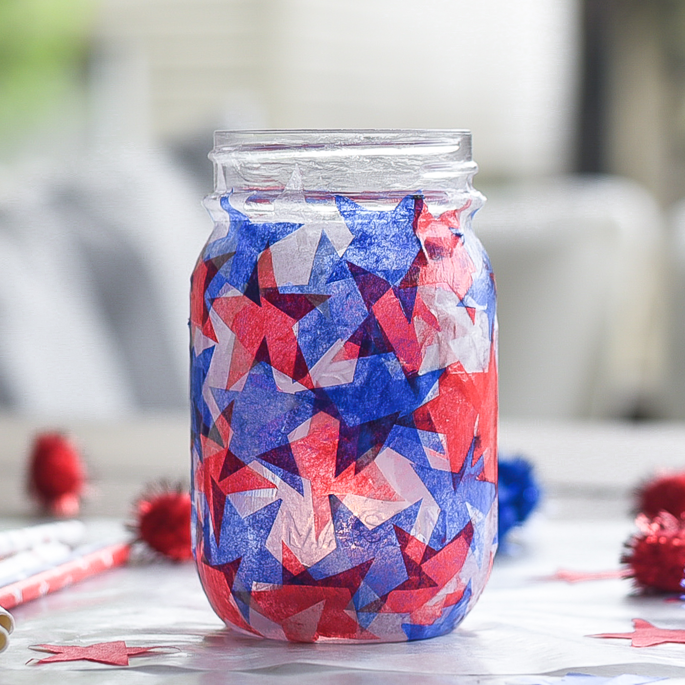 Tissue paper stained glass mason jar craft. Red white blue tissue paper craft. Mod Podge jar in red, white blue. Star shaped tissue paper decoupage mason.