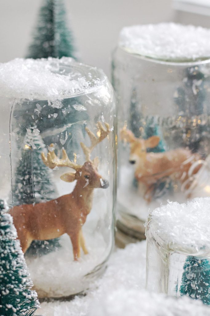 Deers in Forest Mason Jar Snow Globes. Mason Jar Snow Globe Craft Ideas. Bottle Brush Trees in Mason Jar Snow Globes. How to Make a Snow Globe in a Jar. Kids Craft Ideas for Christmas with Mason Jars. Gift Ideas in Mason Jars. Winter Crafts Ideas with Snow Globes. Mason Jar Crafts for Christmas. 