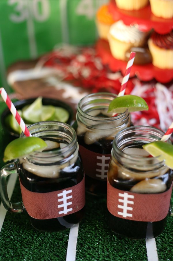 Easy Football Themed Drink Cozies. Football Drink Wrapper. Football Mason Jar Crafts & Party Ideas. Football Party with Mason Jars. Mason Jar Football Centerpiece. Mason jar football drink cups. Mason jar football utensil holder.