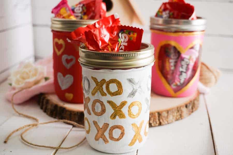 Painted XO's Mason Jars. Valentine Mason Jar Crafts. Mason Jar Valentine's Day Craft Ideas. Gift Ideas in Mason Jars for Valentine's Day. 55+ Valentine Jar Crafts & More