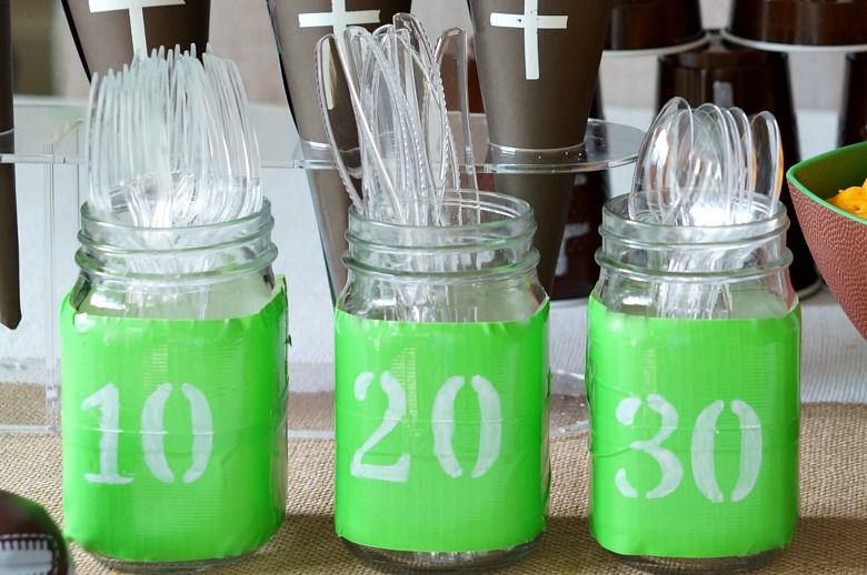 Football Mason Jar Crafts & Party Ideas. Football Party with Mason Jars. Mason Jar Football Centerpiece. Mason jar football drink cups. Mason jar football utensil holder.