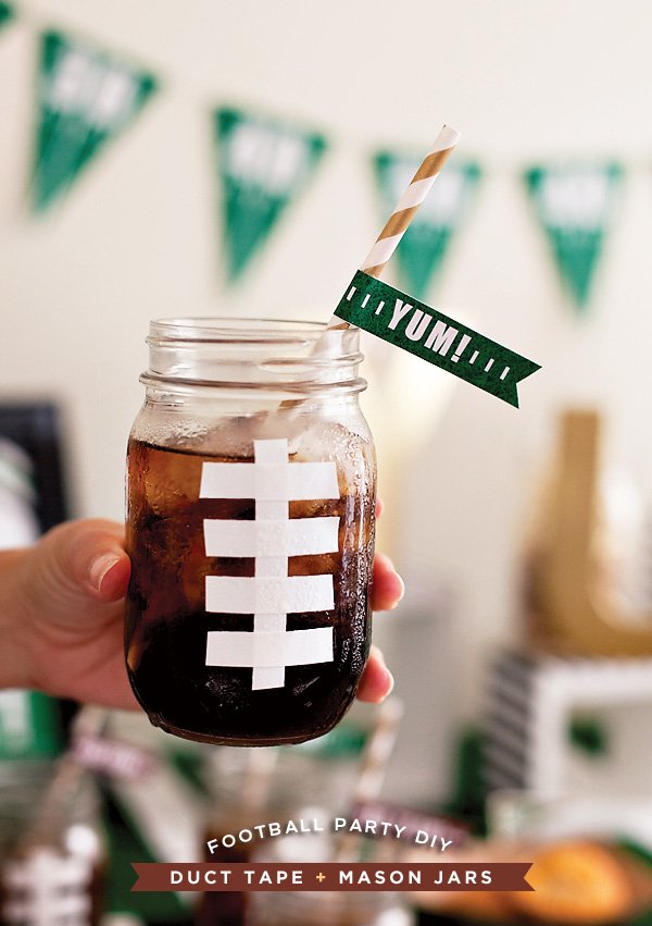 Easy Football Drink Cup with Paper Straw. Football Mason Jar Crafts & Party Ideas. Football Party with Mason Jars. Mason Jar Football Centerpiece. Mason jar football drink cups. Mason jar football utensil holder.