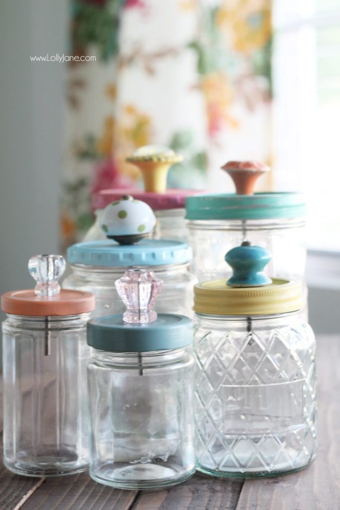 Pretty, colorful mason jar storage jars with glass knob tops. Mason Jar Bathroom Storage and Organization Ideas. Organizing the bathroom with mason jars. Pretty storage ideas with mason jars. Rustic storage ideas with mason jars. Bathroom storage using mason jars.