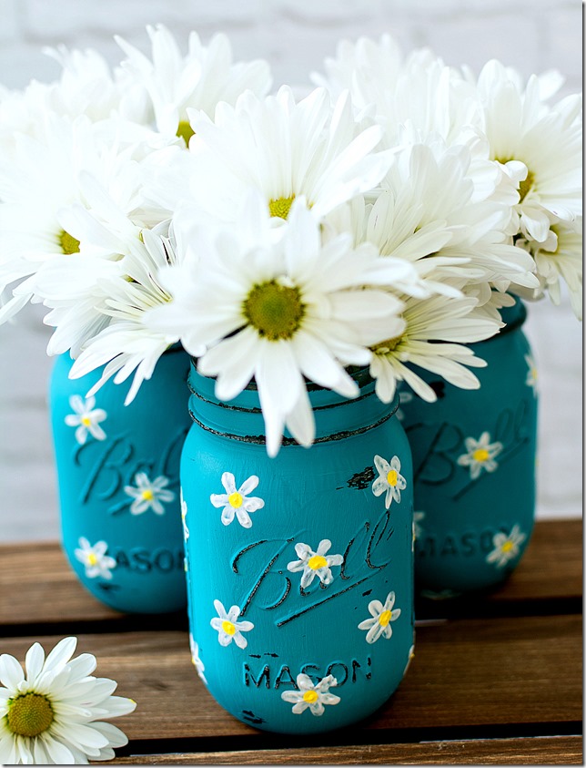How to Paint Daisies on Mason Jars. Teal Mason Jar with Daisies Painted. Summer Mason Jar Crafts. Kid's Craft for Summer with Mason Jars. Coastal Mason Jar Ideas. Painted Mason Jars for Summer. Mason Jar Planters. Twine Wrapped Mason Jar Crafts. Firefly Mason Jars. Mason Jar Votives for Summer.
