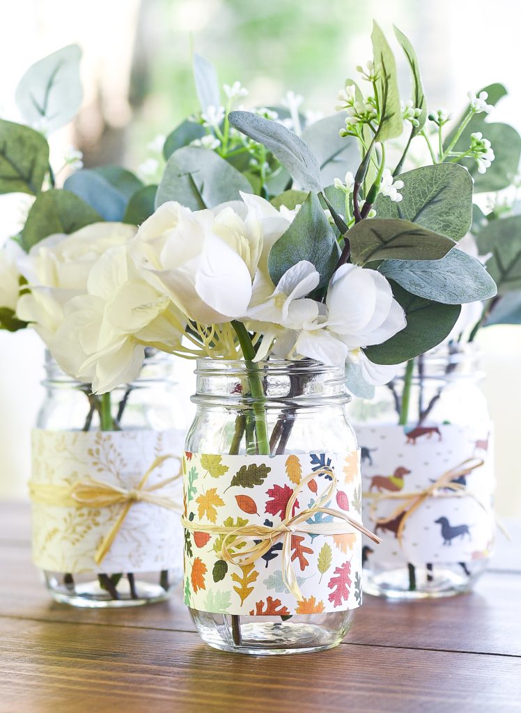 Scrapbook Paper Wrapped Mason Jar with Rafia. Easy Fall Craft Idea with Mason Jars and Scrapbook Paper. Mason Jar Crafts for Fall. 30+ Craft Idea for Autumn. Crafts for Fall with Mason Jars. Mason Jar Autumn Crafts. Painted Mason Jars for Fall. Mason Jar Votives for Fall. Pumpkin Mason Jar Crafts for Fall.